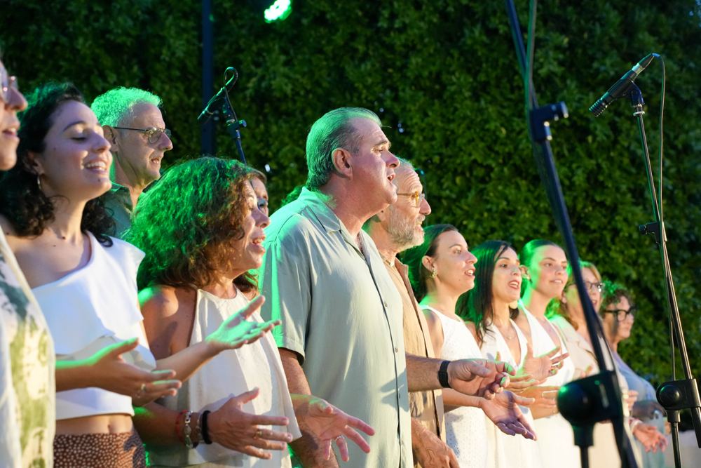 El coro vestido de blanco cantando al aire libre