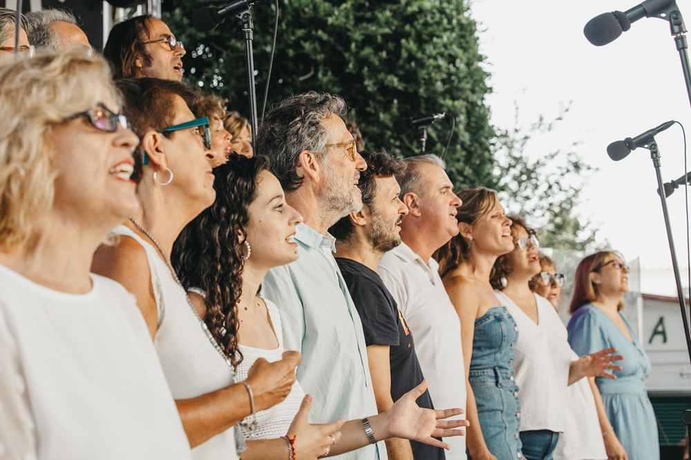 Voces del coro de blanco cantando con emoción