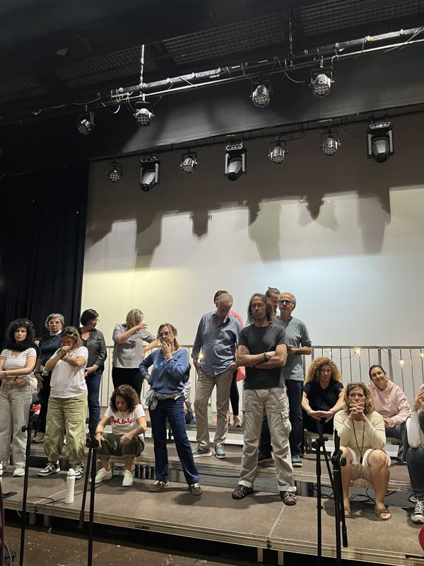 El coro reunido sobre el escenario después de un ensayo
