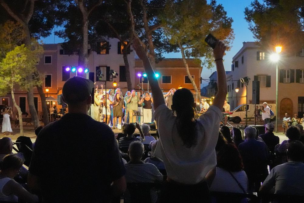 Plaza llena de público en un concierto nocturno