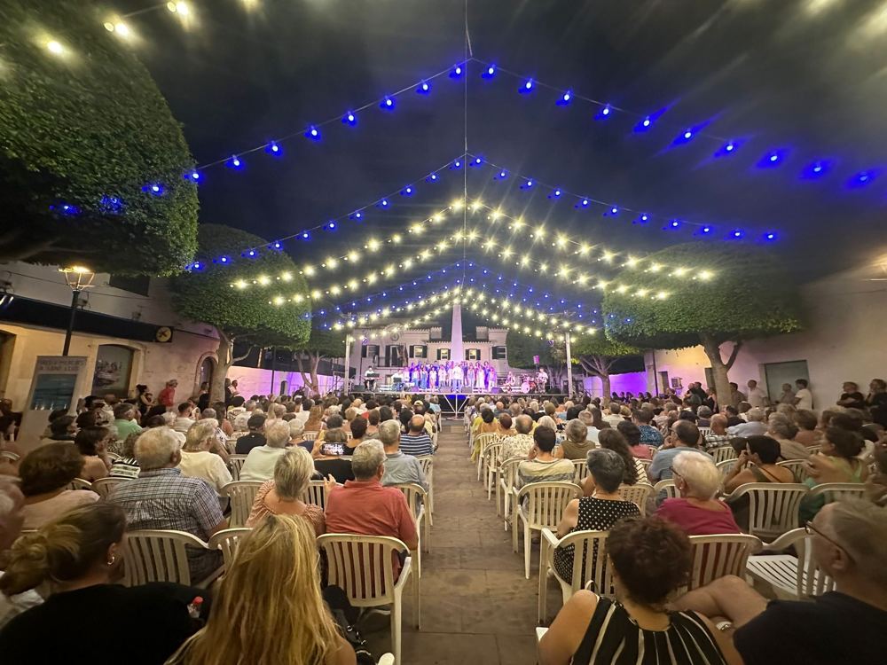 Concierto bajo una carpa iluminada con guirnaldas