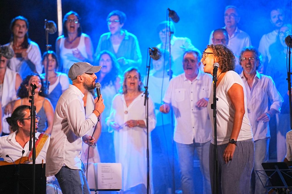Albert cantando entre el coro con luz azul
