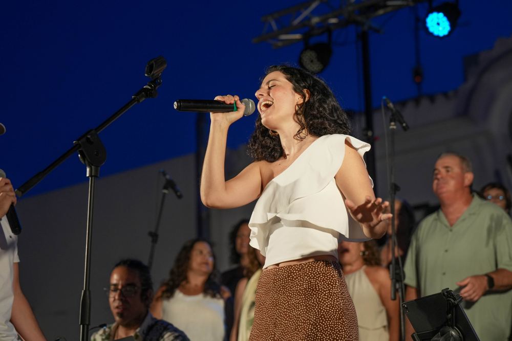 Solista cantando con el coro detrás al anochecer