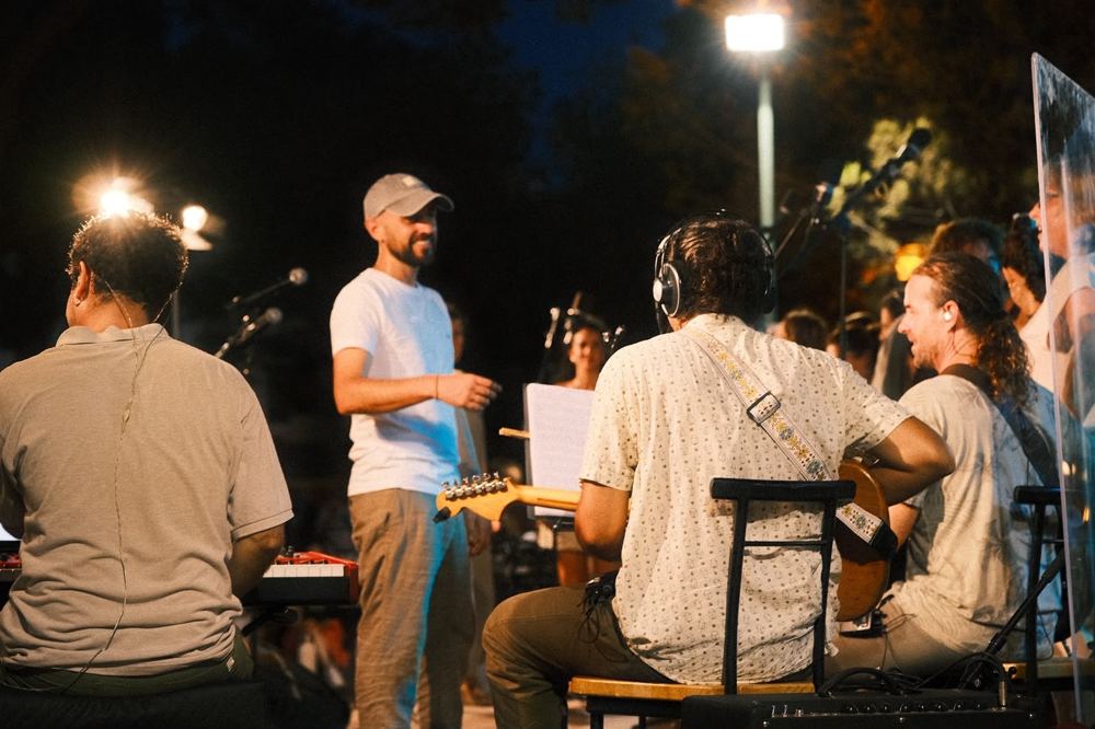Músicos y director en el escenario de noche
