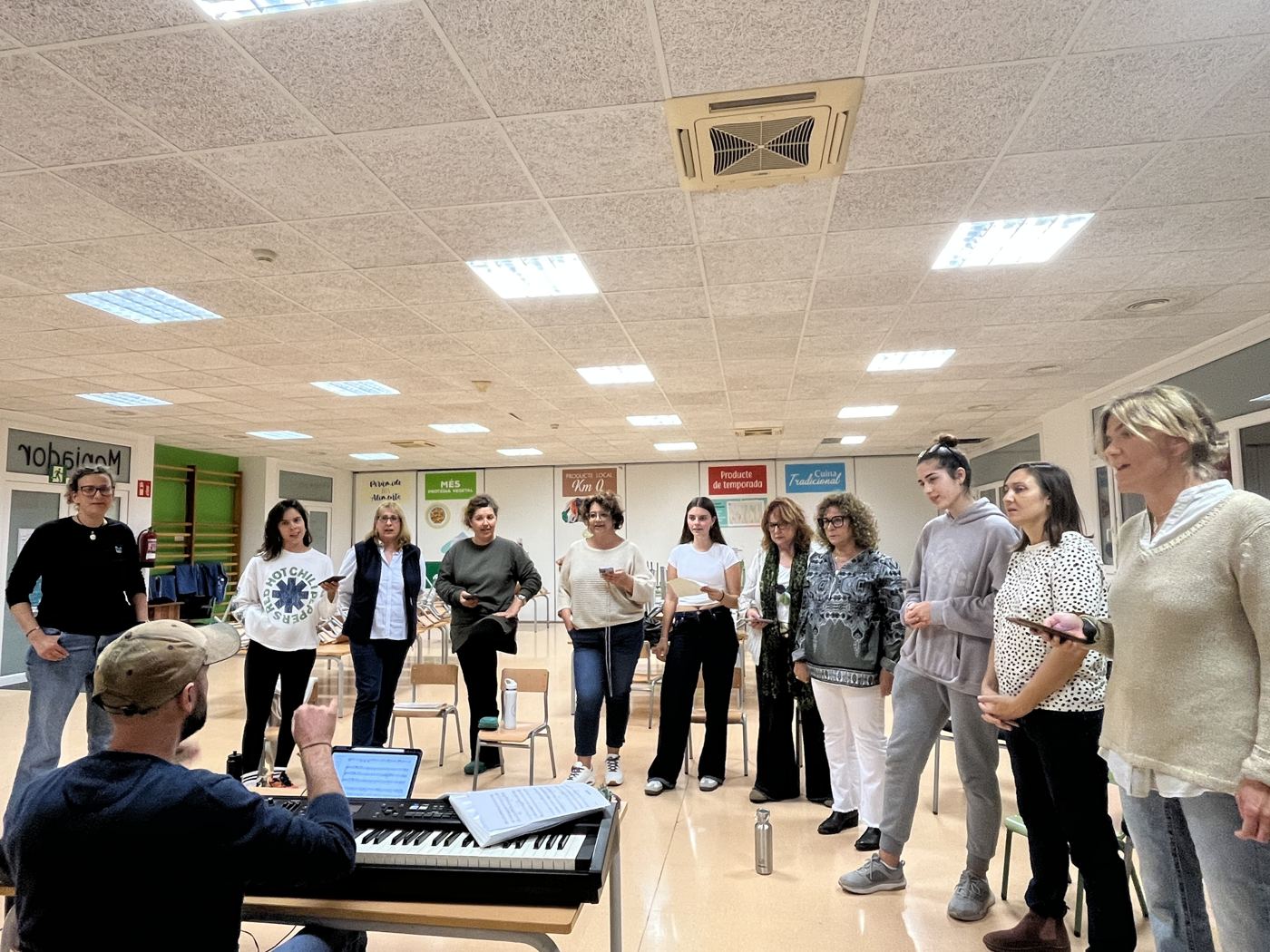 El coro ensayando en la sala, alrededor del piano