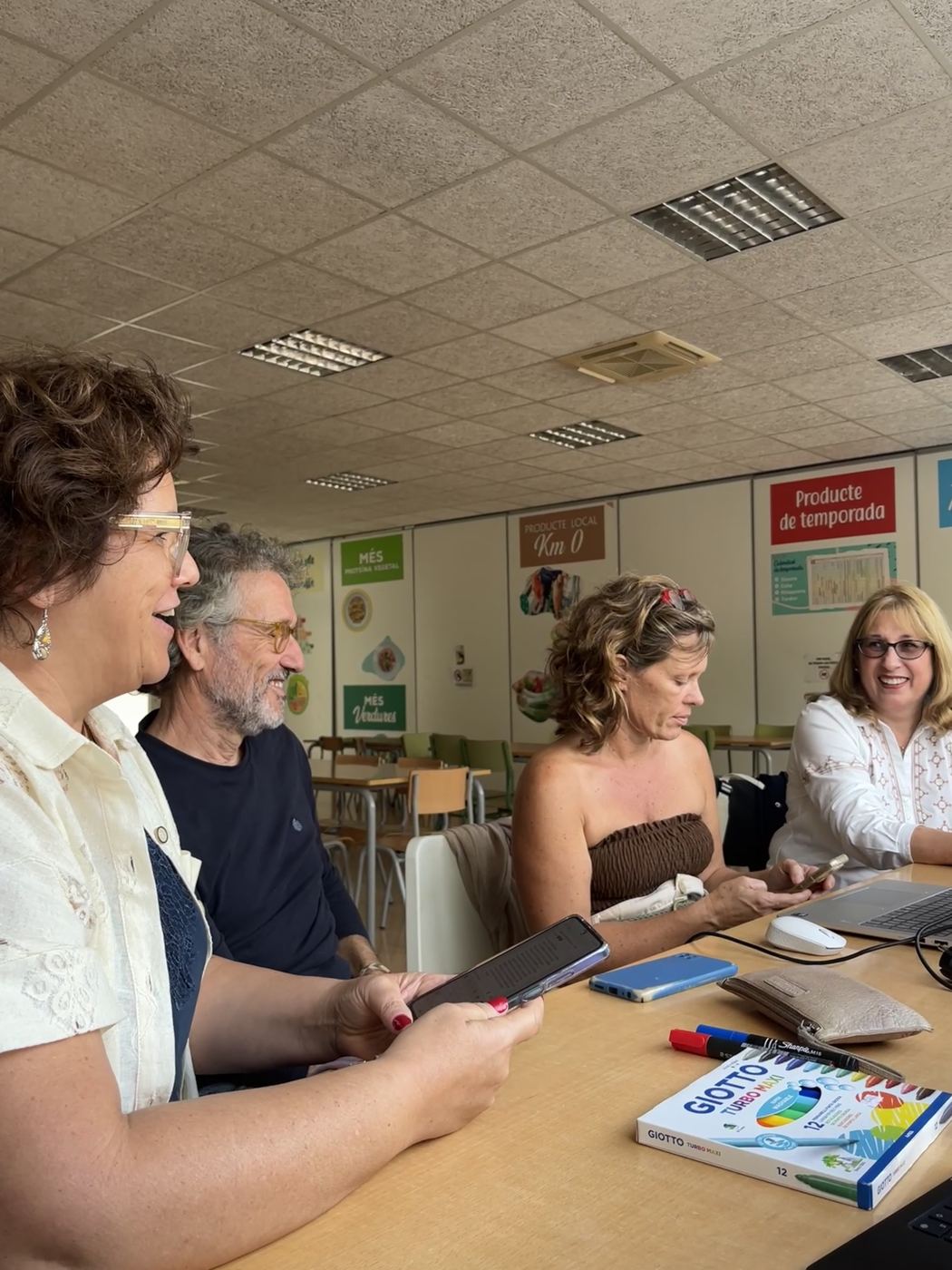 Compañeros del coro repasando partituras alrededor de una mesa
