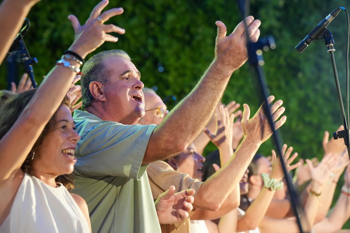 El público aplaudiendo y cantando con los brazos en alto